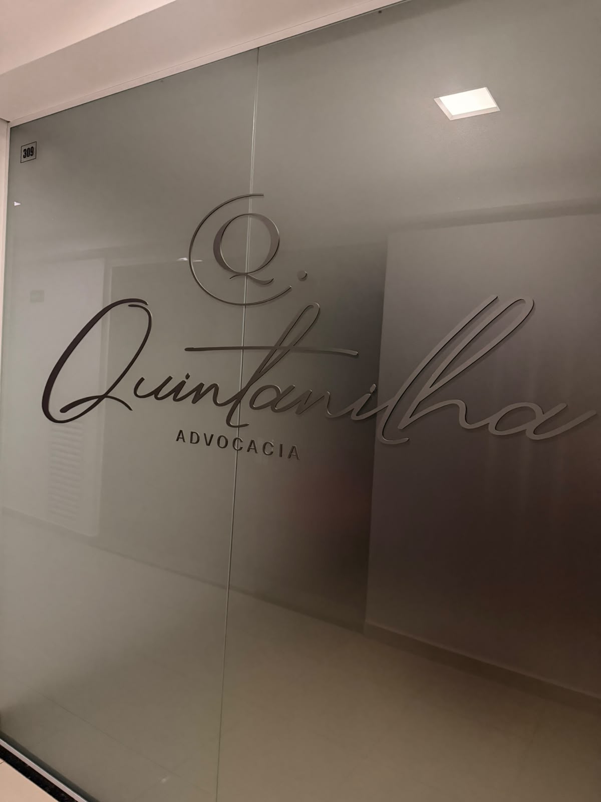 Porta da sala 309 com o logo da Quintanilha Advocacia em relevo